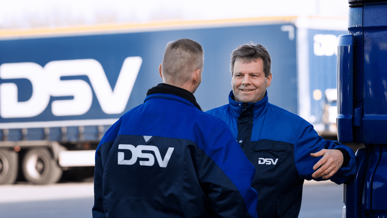 To DSV-medarbeidere i samtale foran en lastebil.
